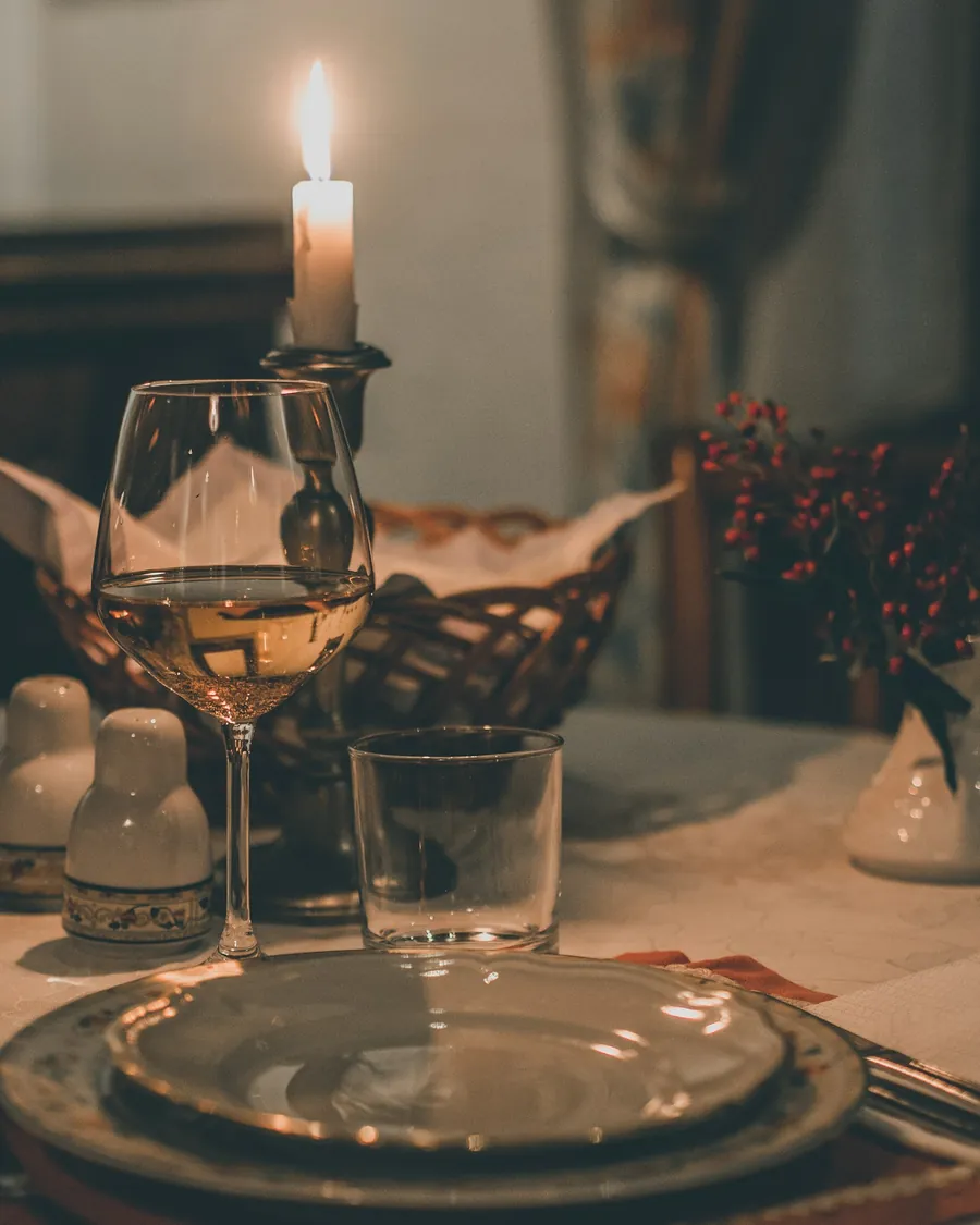 A candlelit dinner table with wine glasses